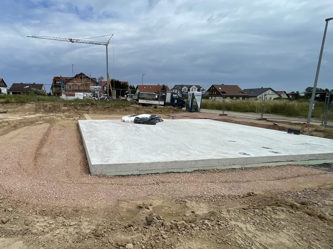 Fertig betonierte Bodenplatte auf verdichtetem Schotterpolster einer Baustelle